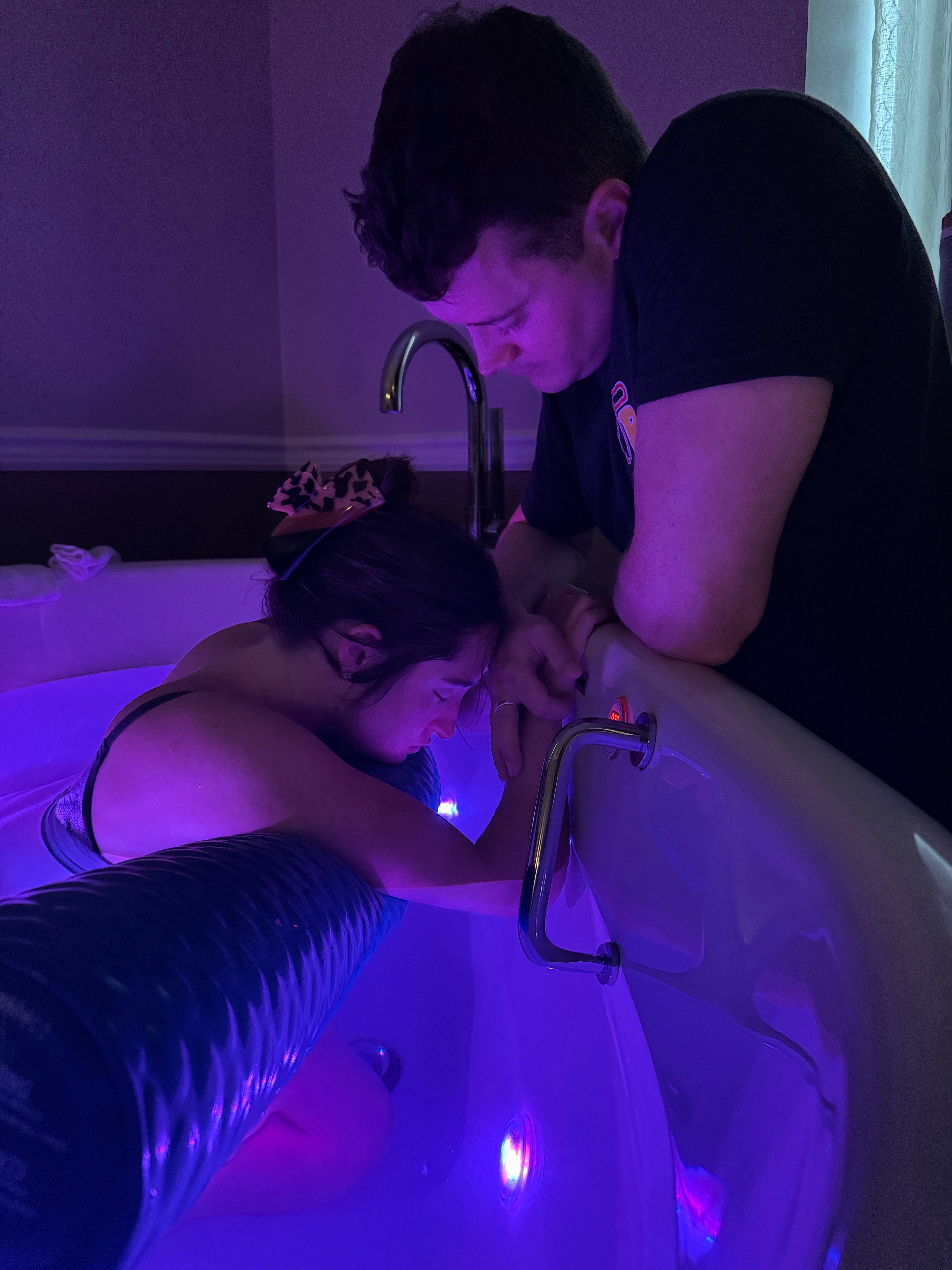 Mackenzie labors in the birthing tub while Finn offers support.